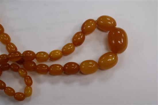 A single strand amber bead necklace, 28grms and an amber cigar holder.